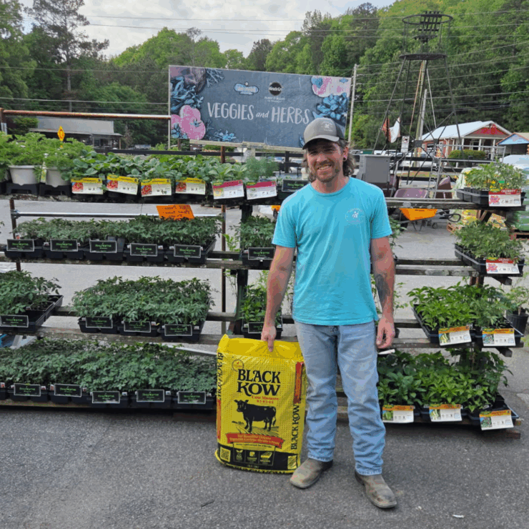 Our employee Will, with a bag of Black Kow Compost, which will definitely Give Your Plants the Ultimate Growing Boost